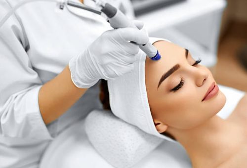 skin-treatment Face Skin Care. Close-up Of Woman Getting Facial Hydro Microdermabrasion Peeling Treatment At Cosmetic Beauty Spa Clinic. Hydra Vacuum Cleaner. Exfoliation, Rejuvenation And Hydratation. Cosmetology.