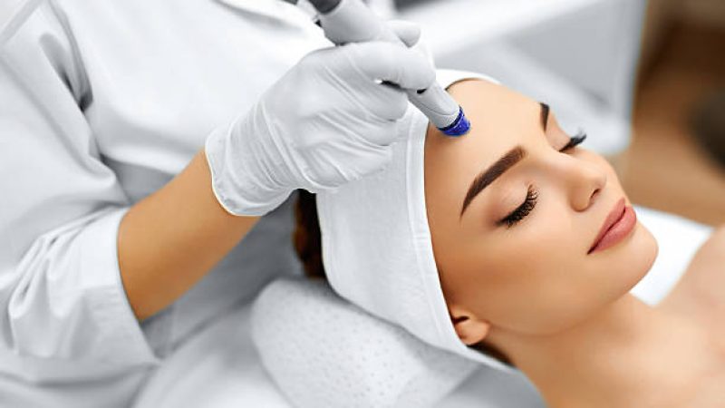 skin-treatment Face Skin Care. Close-up Of Woman Getting Facial Hydro Microdermabrasion Peeling Treatment At Cosmetic Beauty Spa Clinic. Hydra Vacuum Cleaner. Exfoliation, Rejuvenation And Hydratation. Cosmetology.